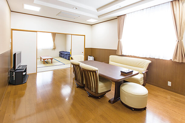 川崎市にある民営葬儀場「平安会館わたりだ」の親族控室の内観写真。ソファのある洋室と、和室が併設されている